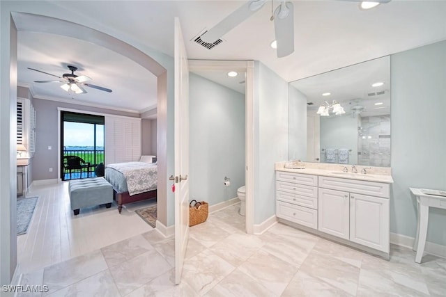 bathroom featuring ornamental molding, ceiling fan, vanity, and toilet