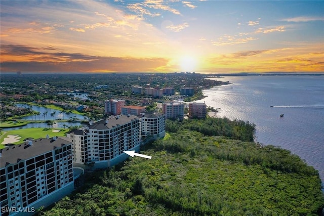 aerial view at dusk featuring a water view