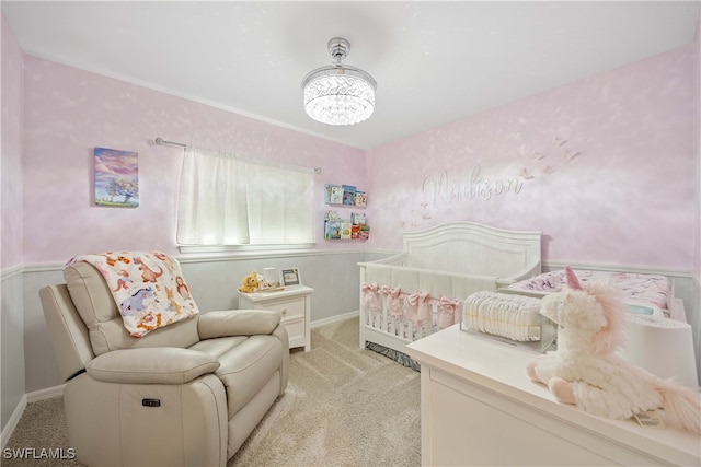 bedroom featuring light colored carpet and a nursery area