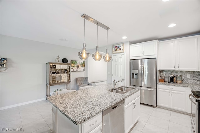 kitchen featuring a kitchen island with sink, appliances with stainless steel finishes, sink, and light tile patterned floors