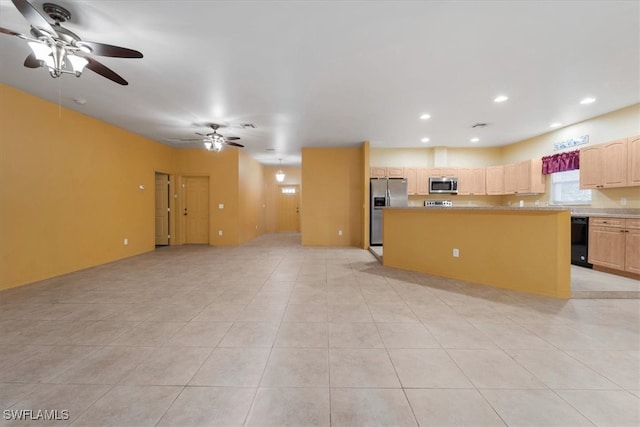 kitchen featuring light tile patterned floors, a center island, stainless steel appliances, light brown cabinets, and ceiling fan