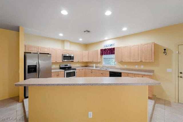 kitchen with a center island, light tile patterned floors, and stainless steel appliances