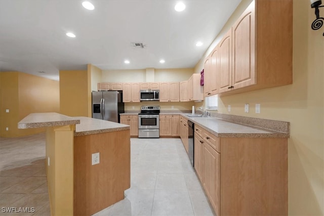 kitchen featuring a breakfast bar, stainless steel appliances, light tile patterned flooring, and sink