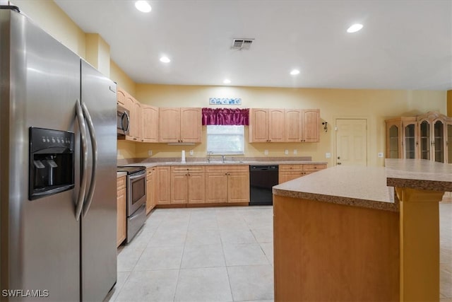 kitchen with appliances with stainless steel finishes, light tile patterned floors, and sink