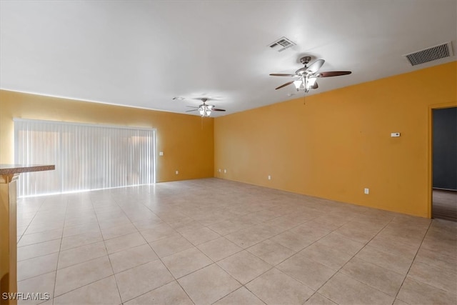 tiled empty room featuring ceiling fan