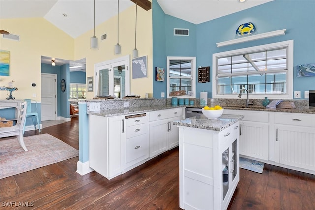 kitchen featuring white cabinetry, light stone countertops, dark hardwood / wood-style flooring, a center island, and hanging light fixtures