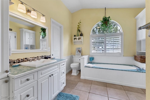 bathroom featuring tile patterned flooring, vanity, a washtub, toilet, and lofted ceiling