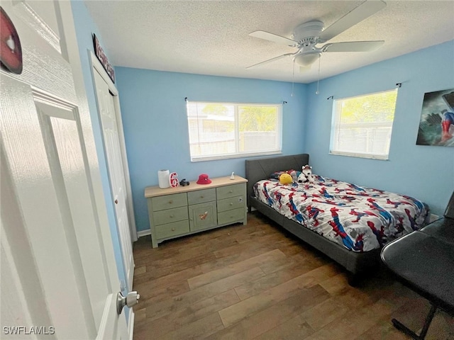 bedroom featuring a textured ceiling, hardwood / wood-style floors, ceiling fan, and a closet