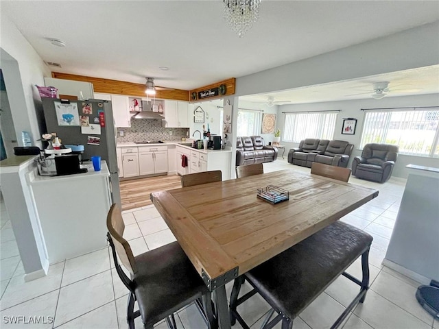 dining area featuring ceiling fan, light tile patterned floors, and sink