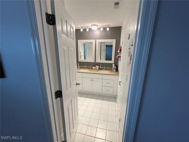 bathroom with tile patterned floors, a textured ceiling, track lighting, and vanity