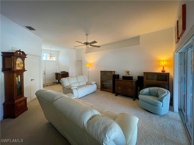 living room featuring ceiling fan with notable chandelier and carpet