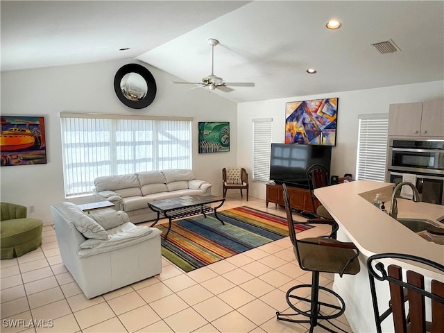 tiled living room with vaulted ceiling, ceiling fan, and sink