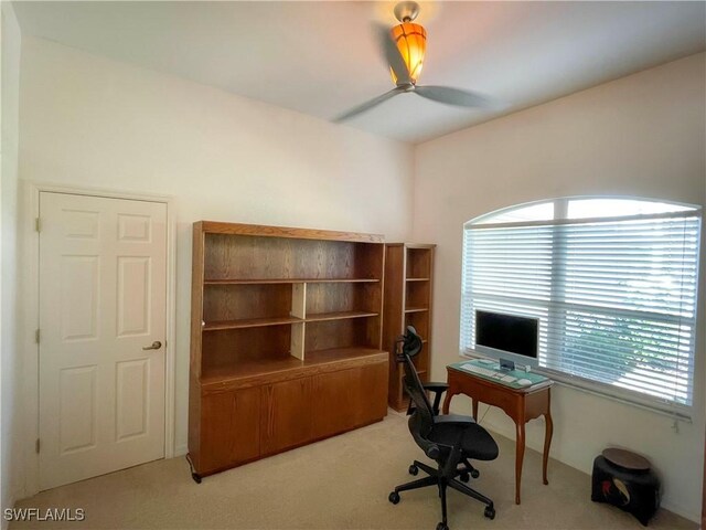 carpeted office space featuring ceiling fan