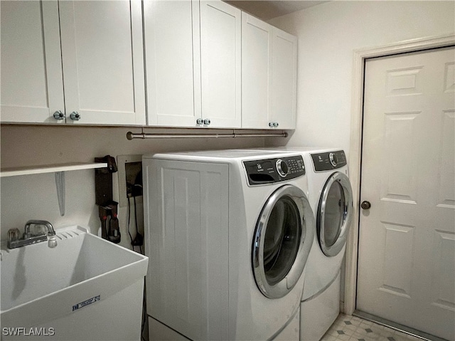 laundry area featuring cabinets, sink, and washer and dryer