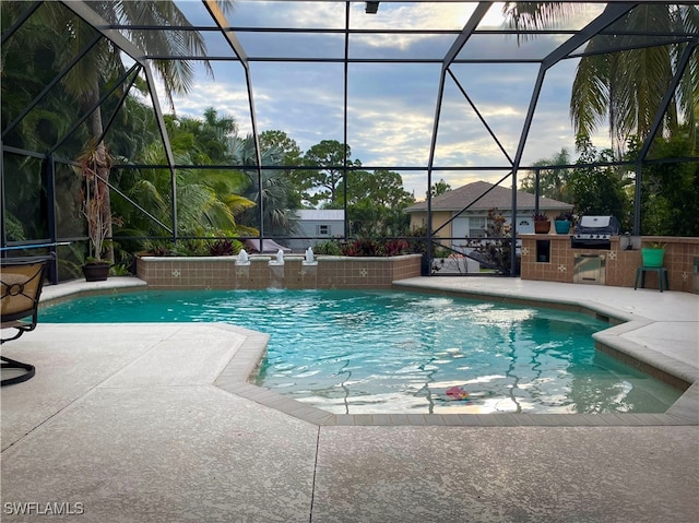 view of swimming pool with grilling area, glass enclosure, a patio, and pool water feature