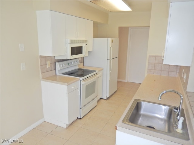 kitchen with white appliances, light tile patterned floors, tasteful backsplash, white cabinetry, and sink