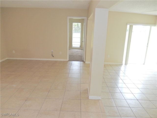 tiled spare room featuring a healthy amount of sunlight