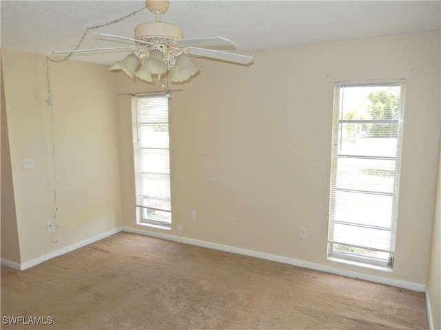 carpeted empty room featuring ceiling fan