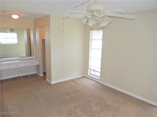 carpeted empty room featuring ceiling fan