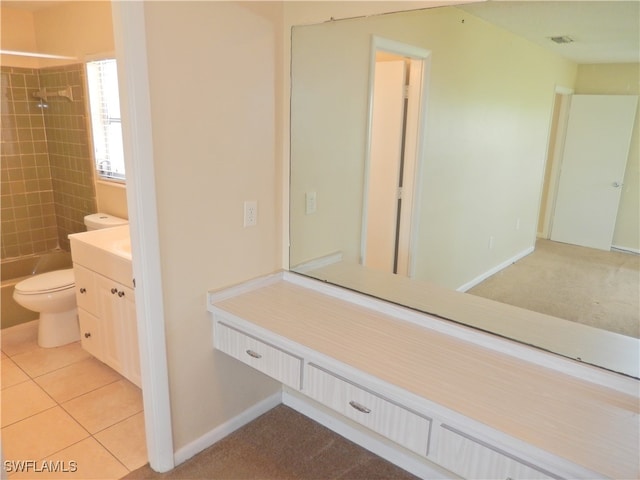 full bathroom featuring tiled shower / bath combo, tile patterned floors, vanity, and toilet