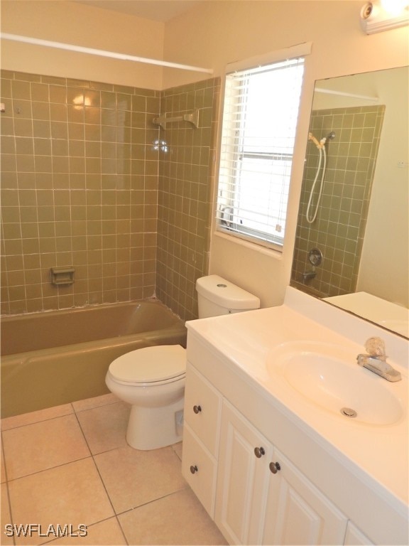 full bathroom featuring toilet, tiled shower / bath combo, tile patterned flooring, and vanity