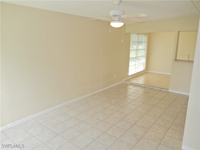 tiled spare room featuring ceiling fan