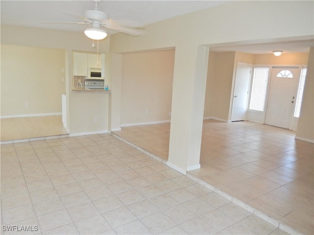 unfurnished room with ceiling fan and light tile patterned floors