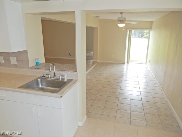 kitchen featuring ceiling fan, decorative backsplash, sink, white cabinetry, and light tile patterned flooring