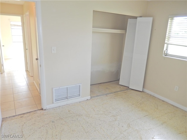 unfurnished bedroom with a closet and tile patterned floors