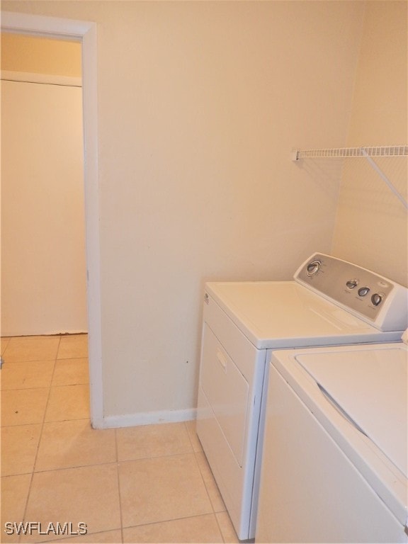 laundry room with washing machine and dryer and light tile patterned flooring