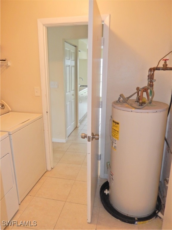 utility room featuring water heater and independent washer and dryer