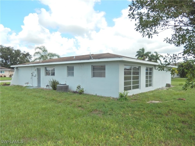 back of property with a yard and cooling unit