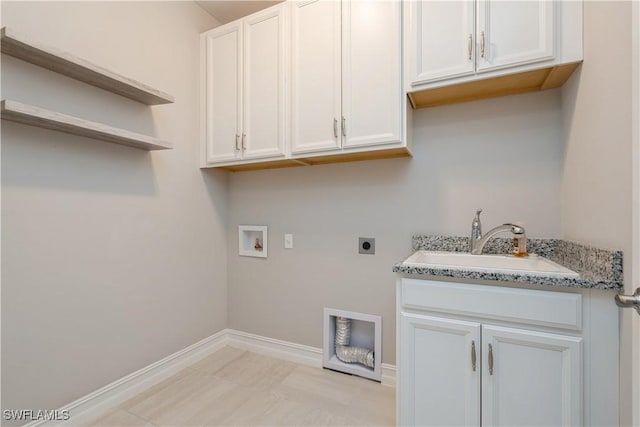 washroom featuring hookup for a washing machine, a sink, baseboards, cabinet space, and electric dryer hookup