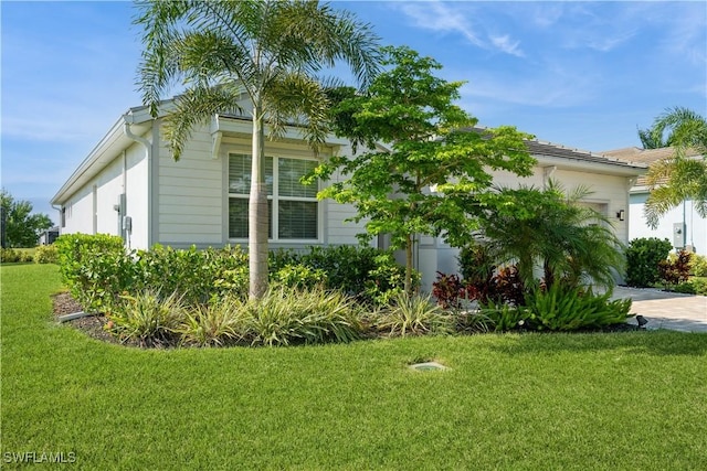 view of home's exterior featuring a garage, a yard, and decorative driveway