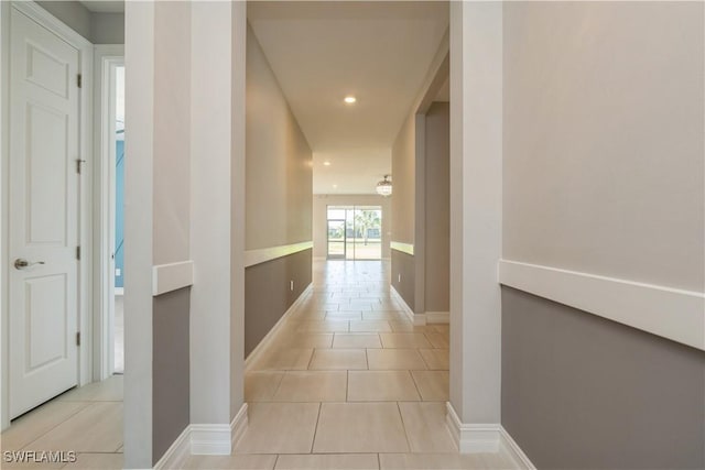 corridor with recessed lighting, baseboards, and light tile patterned floors