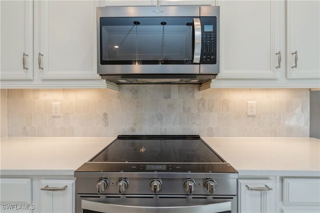 kitchen featuring backsplash, appliances with stainless steel finishes, and white cabinets