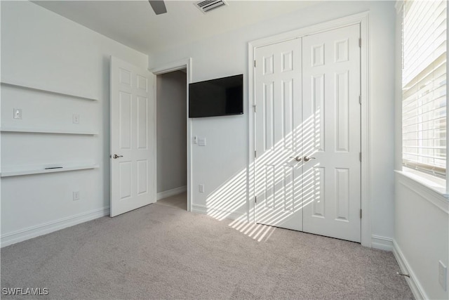 unfurnished bedroom with baseboards, a closet, visible vents, and carpet flooring