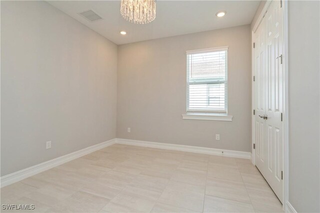 unfurnished room featuring light tile patterned floors and a notable chandelier