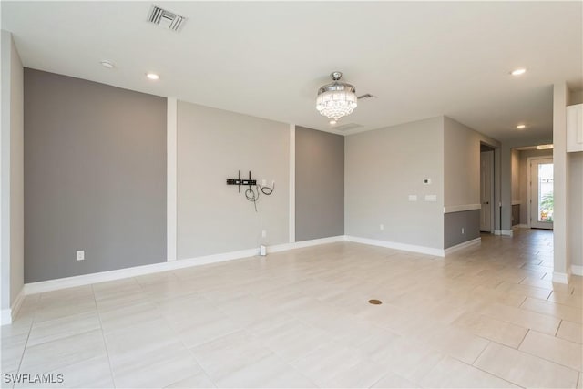 spare room with a notable chandelier, recessed lighting, visible vents, and baseboards