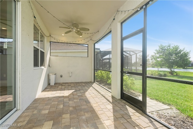 unfurnished sunroom featuring ceiling fan