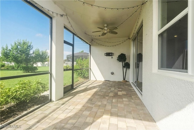 unfurnished sunroom with ceiling fan