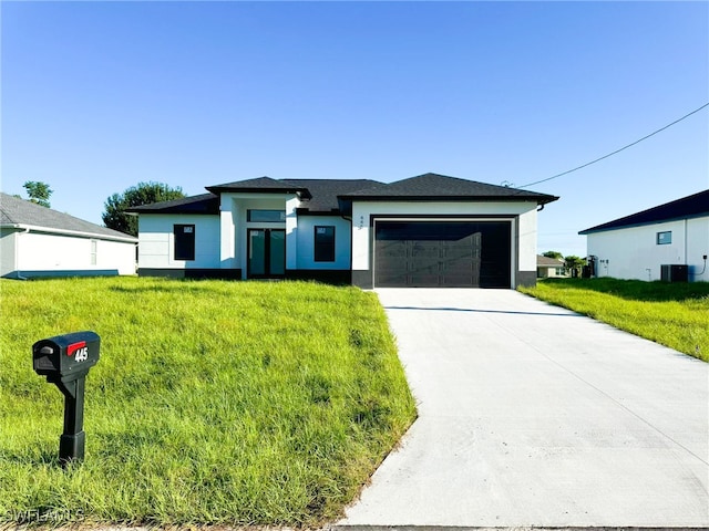 prairie-style house featuring a front lawn, central AC unit, and a garage