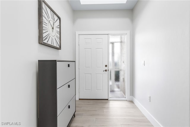 entryway with light wood-type flooring and a skylight