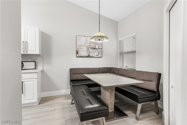 dining room with breakfast area, a wealth of natural light, a chandelier, light hardwood / wood-style floors, and lofted ceiling