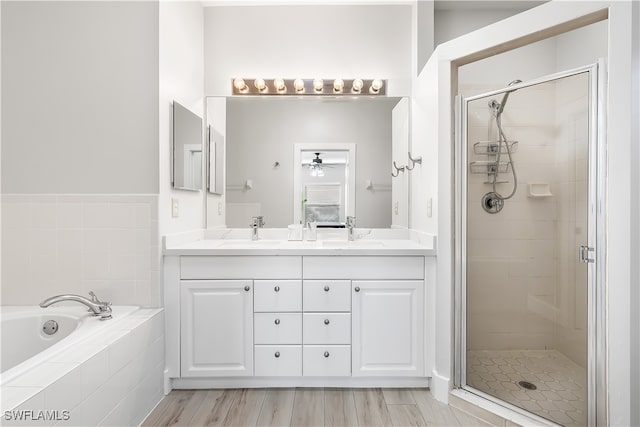 bathroom with ceiling fan, vanity, hardwood / wood-style floors, and separate shower and tub