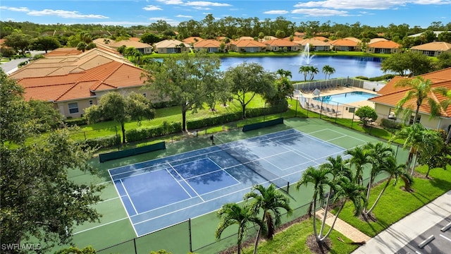 view of tennis court featuring a water view