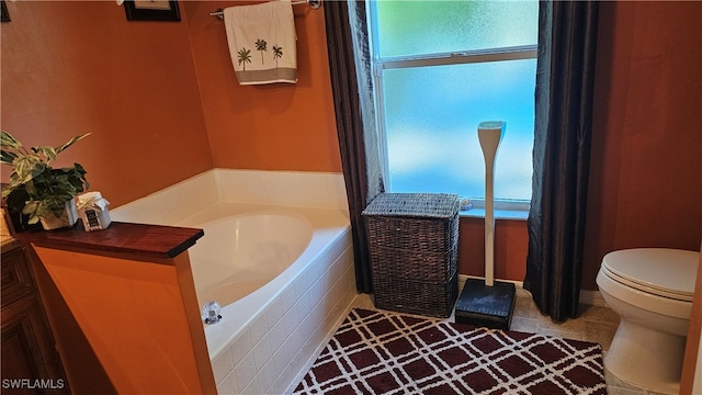 bathroom with tile patterned flooring, toilet, and tiled tub