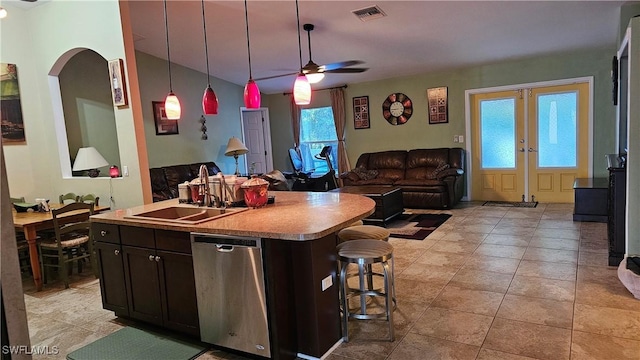 kitchen with stainless steel dishwasher, plenty of natural light, a kitchen island with sink, and sink