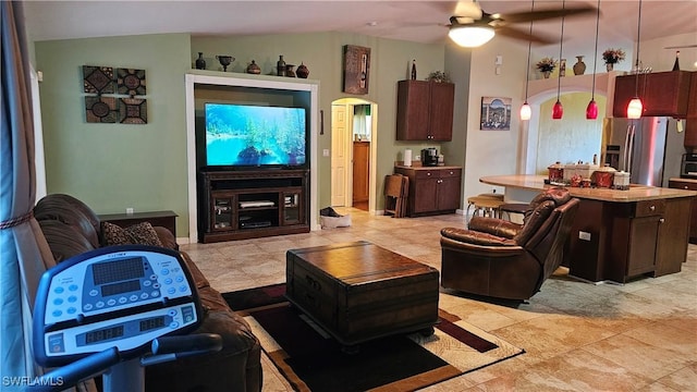 living room featuring ceiling fan, lofted ceiling, and light tile patterned floors