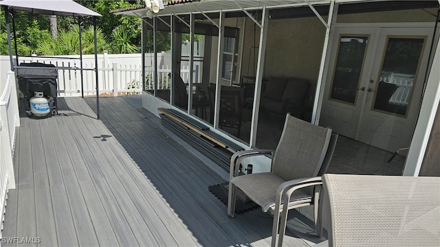 wooden deck with french doors and a sunroom